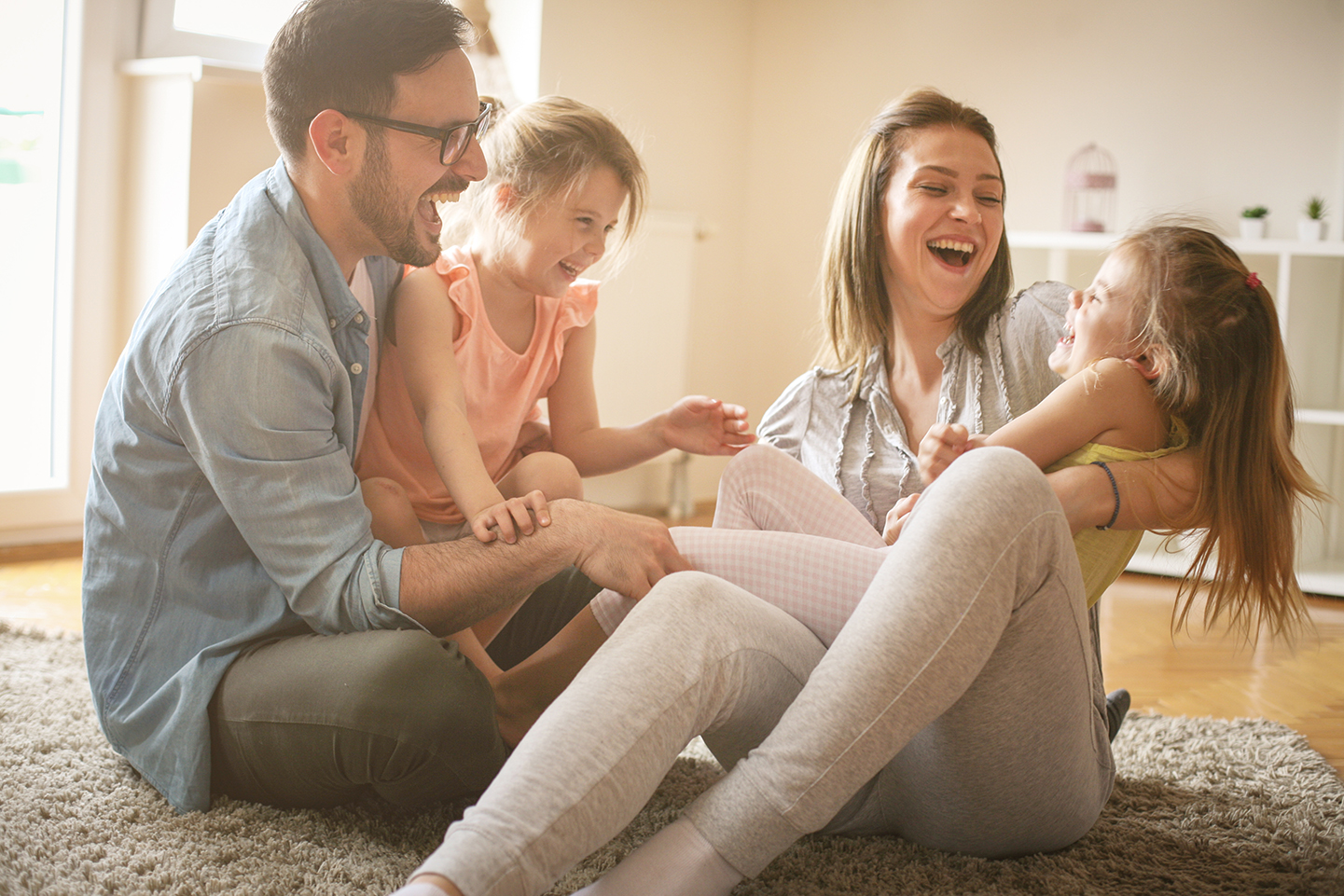 Happy family playing with two daughters